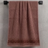 Klasyczny ręcznik łazienkowy 50x100 w kolorze zgaszonego, brudnego różu (lub jasnego brązu) z serii Alba, zawieszony na czarnym wieszaku ściennym.