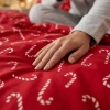 Zbliżenie na gładką tkaninę pościelową premium z wyraźnym nadrukiem świątecznej laski cukrowej w białe paski