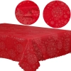 Stół udekorowany czerwonym obrusem świątecznym w srebrne wzory i świecami