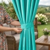 Sposób eleganckiego upięcia jasnej zasłony do altany za pomocą dołączonej do zestawu materiałowej szarfy
