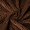 ekstura miękkiej mikrofibry brązowego szlafroka ułożona w przestrzenną falę ukazująca gęstość materiału