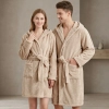 Uśmiechnięta para w łazience ubrana w grube beżowe szlafroki kąpielowe z kapturem z miękkiej mikrofibry