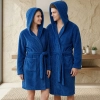 Uśmiechnięta para w łazience ubrana w grube niebieskie szlafroki kąpielowe z kapturem z miękkiej mikrofibry