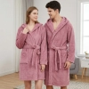 Uśmiechnięta para w łazience ubrana w grube szlafroki kąpielowe z kapturem z miękkiej mikrofibry w kolorze pudrowego róż