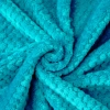 Tekstura miękkiej mikrofibry w kolorze turkusowym ułożona w przestrzenną falę ukazująca gęstość materiału