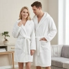 Uśmiechnięta para w jasnym pokoju ubrana w grube białe szlafroki kąpielowe z kapturem z miękkiej mikrofibry