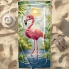 Ręcznik plażowy z mikrofibry z różowym flamingiem i tropikalnymi roślinami, rozłożony na piasku obok kapelusza i klapków