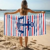 Kobieta na plaży trzymająca rozłożony duży ręcznik plażowy z mikrofibry z marynarskim nadrukiem kotwicy. Sklep TwójDomNa5.pl