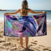 Kobieta na plaży trzymająca rozłożony duży ręcznik plażowy z mikrofibry z hipnotyzującym nadrukiem delfina. Sklep TwójDomNa5.pl
