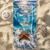 Duży ręcznik plażowy XXL z mikrofibry z fotorealistycznym rekinem i rozgwiazdą pod wodą, rozłożony na piasku obok kapelu