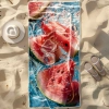 Szybkoschnący ręcznik plażowy z mikrofibry ze wzorem soczystych arbuzów, rozłożony na piasku obok białego kapelusza - Tw