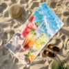 Wielki ręcznik plażowy Serena z letnim motywem napojów i kostek lodu leżący na piaszczystej plaży - TwójDomNa5.pl