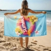 Kobieta na plaży trzymająca rozłożony ręcznik z mikrofibry z wakacyjnym motywem kółka - TwójDomNa5.pl