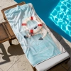 Chłonny ręcznik na basen ze wzorem morskim rozłożony na drewnianym leżaku - TwójDomNa5.pl