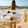 Kobieta tyłem trzymająca rozłożony ręcznik z motywem koła ratunkowego i deski surfingowej - TwójDomNa5.pl