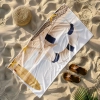 Ręcznik plażowy niełapiący piasku ze wzorem w stylu vintage ułożony ukośnie na plaży