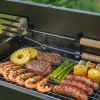 Pojemny ruszt do grilla przenośnego pełen jedzenia: steki, krewetki, kiełbasy i warzywa. Wszechstronny węglowy grill turystyczny idealny do urozmaiconego grillowania.