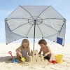 Dzieci bawiące się w piasku i budujące zamek pod chroniącym przed słońcem parasolem plażowym Plażowa Oaza.