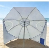 Frontowy widok na rozłożony wielofunkcyjny parasol plażowy Plażowa Oaza wbity w piasek na plaży.