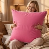 Kobieta z dużą różową poduszką z bawełny wsypowej w sypialni