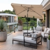 Elegancki beżowy parasol balkonowy Zenith 125x200 cm z falbaną, zamontowany na nowoczesnym tarasie widokowym z szarymi meblami wypoczynkowymi.