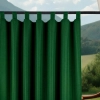 Górna część zasłony ogrodowej w kolorze butelkowej zieleni zawieszonej na czarnym karniszu za pomocą szerokich materiałowych szelek