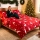 Komplet czerwonej bawełnianej pościeli ze świątecznym motywem skaczących białych reniferów i gwiazdek rozłożony na łóżku