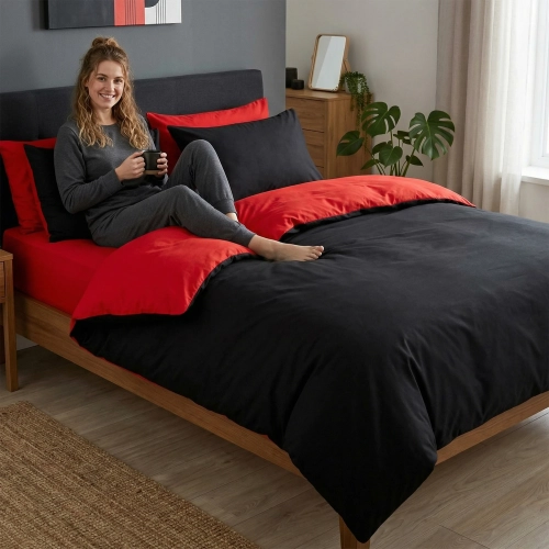 Kobieta siedząca na łóżku z dwustronną pościelą czarno-czerwoną