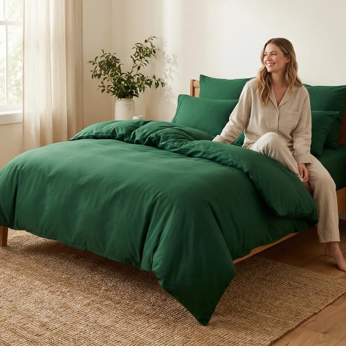 Kobieta relaksuje się na łóżku obleczonym w luksusową pościel J&W w kolorze butelkowej zieleni.