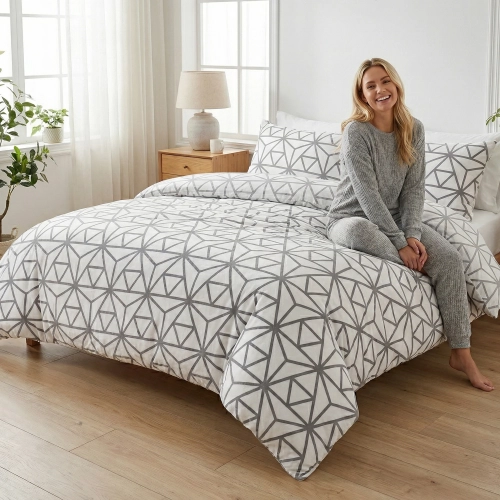 Łóżko zaścielone elegancką, białą pościelą z bawełny J&W we wzór jasnych linii, w otoczeniu jasnej sypialni.