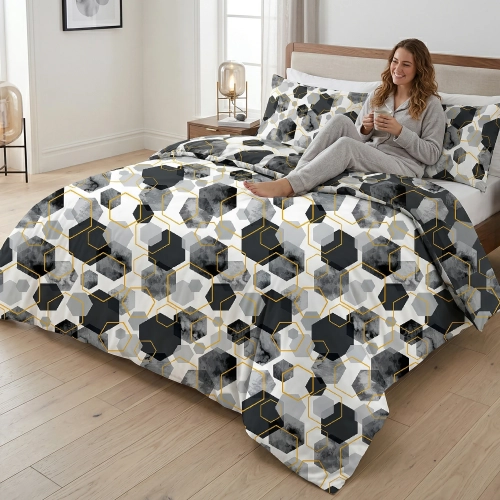 Uśmiechnięta kobieta w szarej piżamie relaksuje się na łóżku z nowoczesną, geometryczną pościelą z bawełny premium J&W.