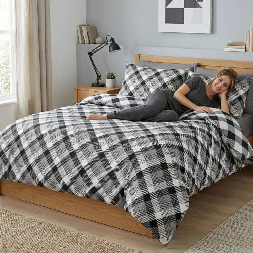 Elegancka pościel bawełniana J&W we wzór geometryczny, prezentująca się w pełnej światła, luksusowej sypialni.