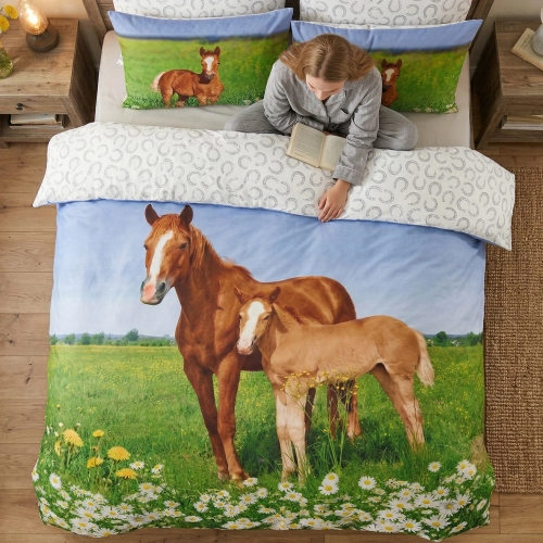 Kobieta relaksująca się z książką na łóżku z wygodną pościelą bawełnianą J&W we wzór koni.