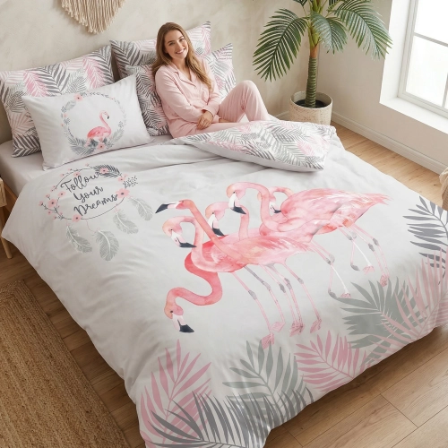 Kobieta relaksująca się na łóżku z jasną, wygodną pościelą bawełnianą J&W we wzór flamingów i łapaczy snów.