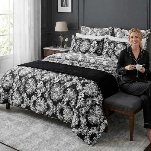 Kobieta uśmiecha się siedząc na łóżku w sypialni, zaścielonym w wygodną pościel bawełnianą J&W w graficzny wzór.