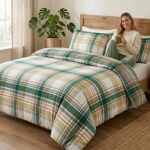 Łóżko w pełnej światła sypialni, zaścielone w radosną pościel bawełnianą J&W we wzór zielono-białej kraty.