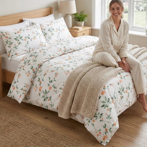 Kobieta relaksująca się na łóżku w sypialni, zaścielonym w wygodną pościel bawełnianą J&W we wzór wiosennych kwiatów.