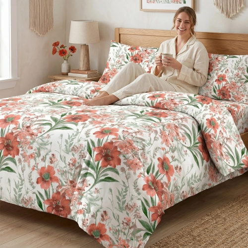 Kobieta relaksująca się na łóżku z białą, wygodną pościelą bawełnianą J&W we wzór letnich, koralowych kwiatów.