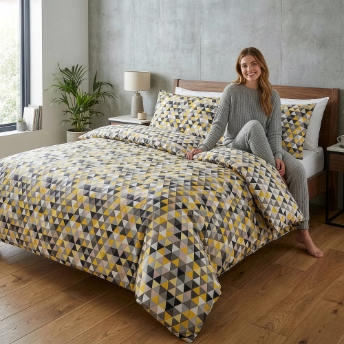 Kobieta siedząca na łóżku z pościelą w kolorowe geometryczne trójkąty