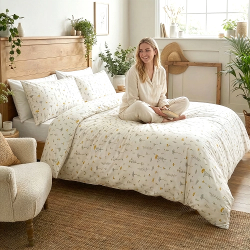 Kobieta relaksująca się na łóżku z pościelą w drobne białe i żółte kwiatki