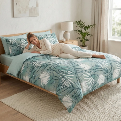 Uśmiechnięta kobieta na drewnianym łóżku w pościeli z satyny bawełnianej w liście z kolekcji Egzotyczne Liście