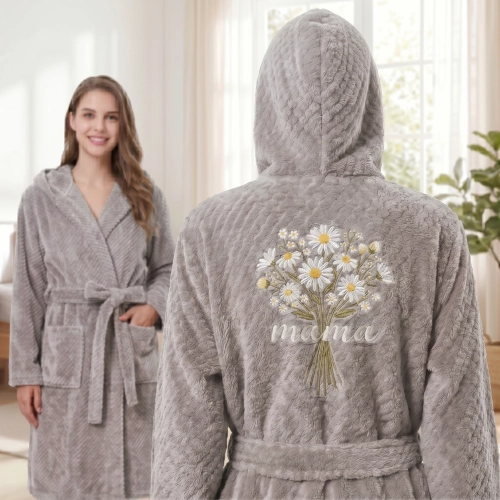 Uśmiechnięta kobieta stojąca przodem w eleganckiej, jasnej sypialni, ubrana w ciepły szlafrok z mikrofibry w kolorze jas