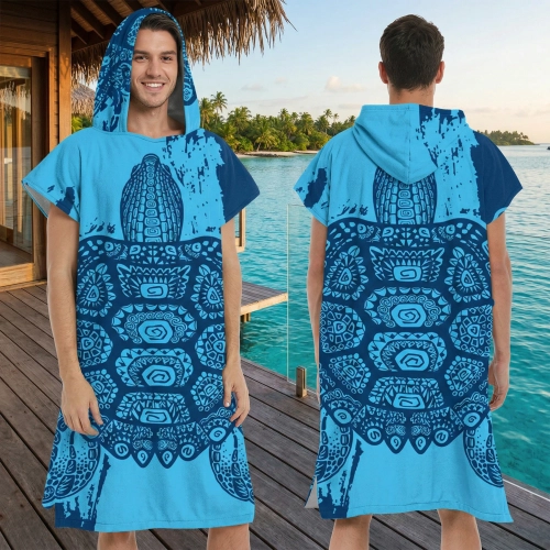 Uśmiechnięty mężczyzna w niebieskim ponchu plażowym z mikrofibry z plemiennym wzorem żółwia, stojący na drewnianym pomoś