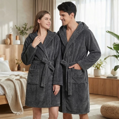 Uśmiechnięta para w łazience ubrana w grube ciemnoszare szlafroki kąpielowe z kapturem z miękkiej mikrofibry