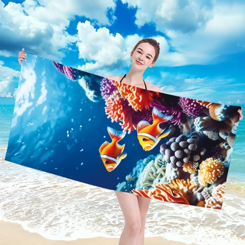 Uśmiechnięta kobieta w bikini trzymająca poziomo rozłożony duży ręcznik plażowy z mikrofibry z motywem podwodnego świata