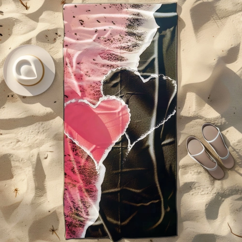 Duży ręcznik plażowy XXL z mikrofibry z artystycznym wzorem różowo-czarnego serca, rozłożony na piasku obok kapelusza -