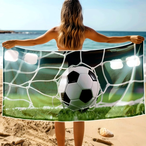 Kobieta na plaży trzymająca rozłożony ręcznik XXL z piłką w siatce bramki - TwójDomNa5.pl
