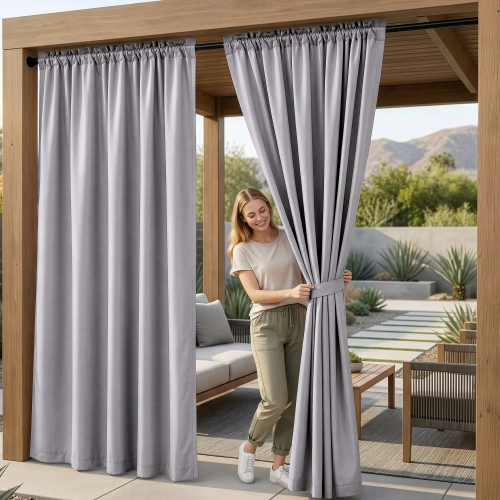 Kobieta na tarasie pod drewnianą pergolą upinająca wodoodporne popielate zasłony ogrodowe