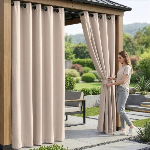 Kobieta na tarasie pod drewnianą pergolą upinająca wodoodporne beżowe zasłony ogrodowe na przelotkach