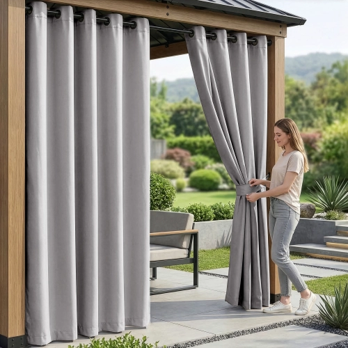 Kobieta na tarasie pod nowoczesną pergolą upinająca wodoodporne popielate zasłony ogrodowe na przelotkach